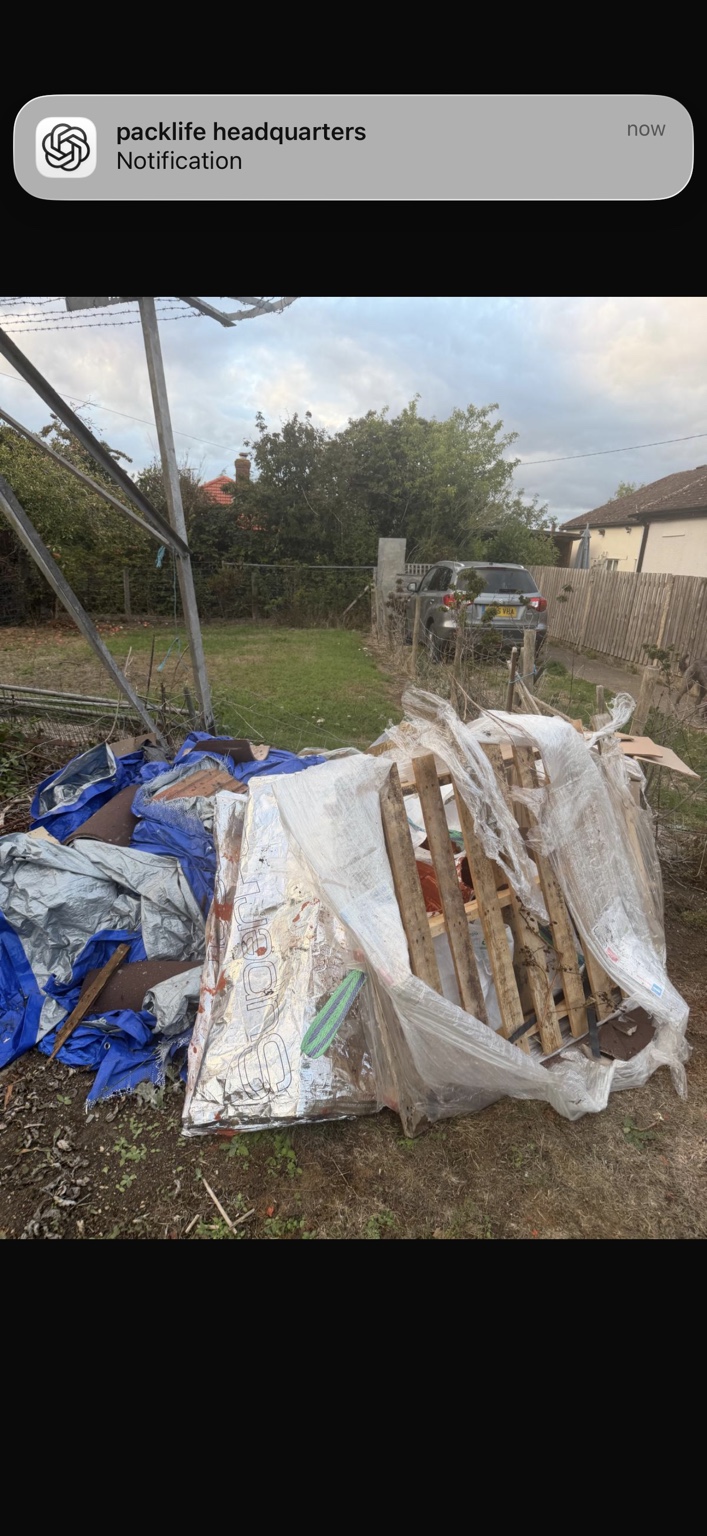 Bulky garden and refurbishment waste, including timber and pallets, awaiting collection.